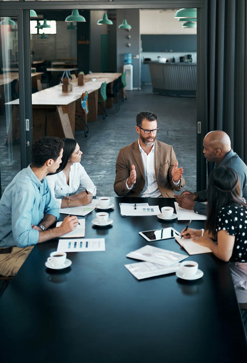 Team diversity, business and meeting at table to have conversation for group project, planning or strategy for startup company in office. Brainstorming, teamwork and communicate finance in workspace